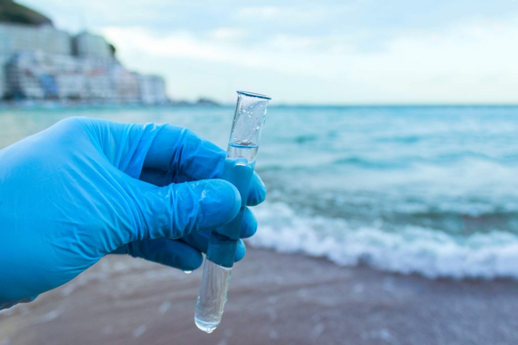 Analyse d'un échantillon d'eau d'une rivière ou d'une mer, d'un océan. Le scientifique a pris de l'eau dans un tube à essai.